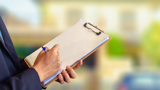 Woman writing on a clipboard