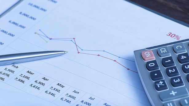 Economic report with calculator next to it