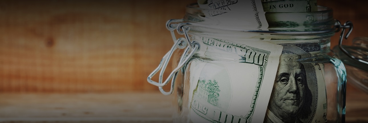 Large ddollar bills rolled and placed in a mason jar
