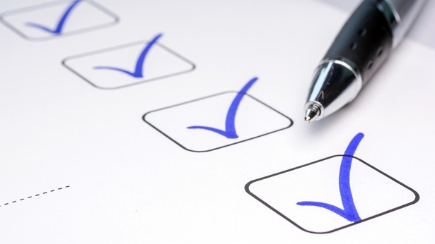 A checklist with checkmarks and a pen